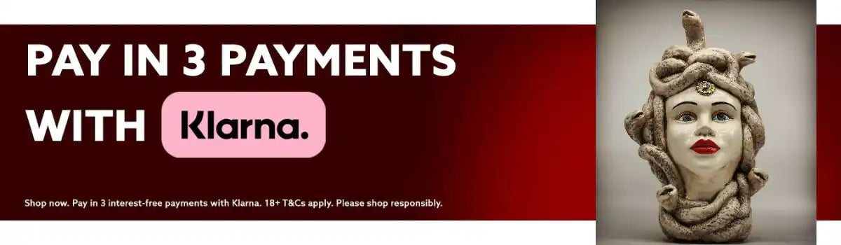 Un busto in ceramica di Medusa con serpenti come capelli e labbra rosse.