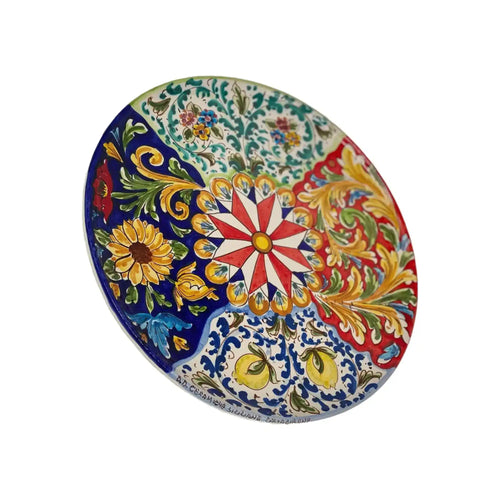 Piatto decorativo in ceramica con motivi floreali e geometrici colorati in stile mediterraneo.